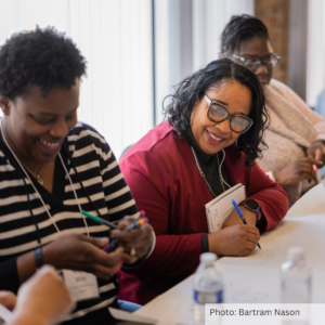 Three women laughing together during a COFI Center workshop