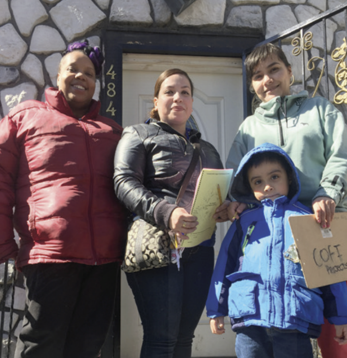 POWER-PAC IL leaders pose for a photo with a local family while conducting a survey on debt