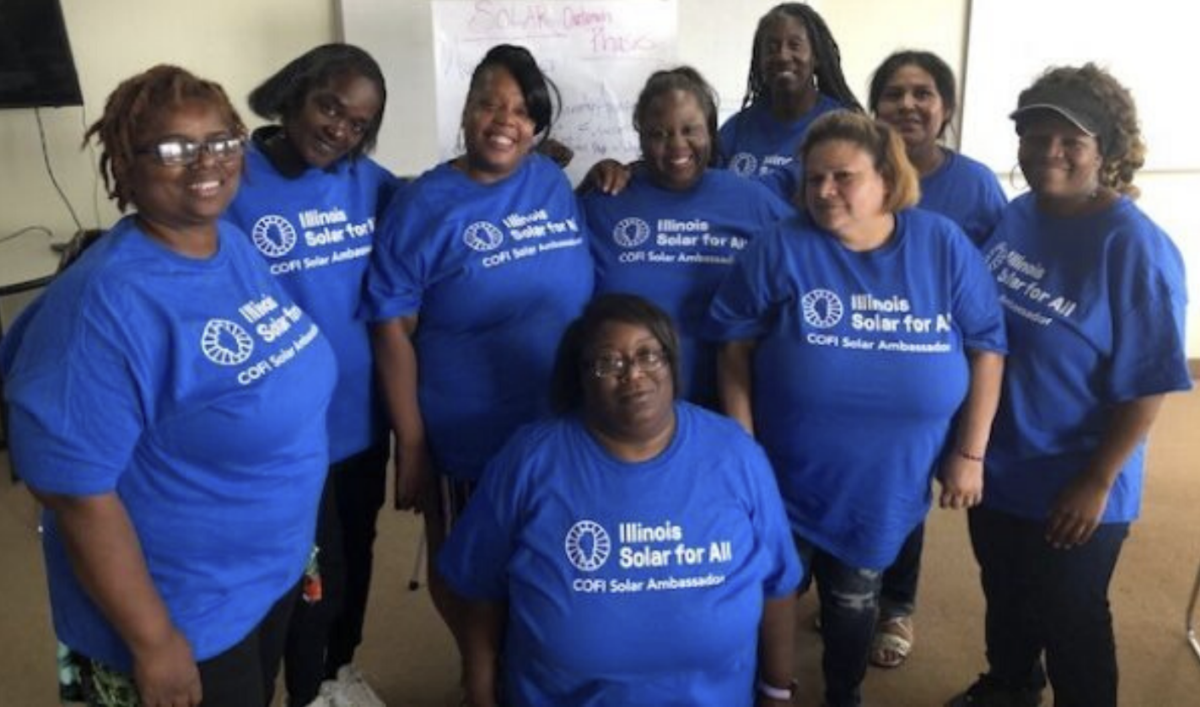 Un grupo de mujeres con camisetas azules a juego de Illinois Solar for All