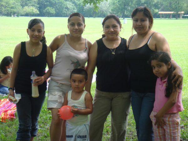 Three moms pose with three children outside 