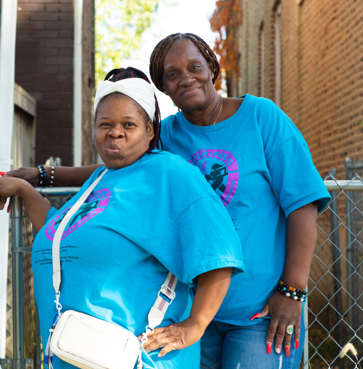 Two women in matching blue POWER-PAC IL shirts pose for a photo