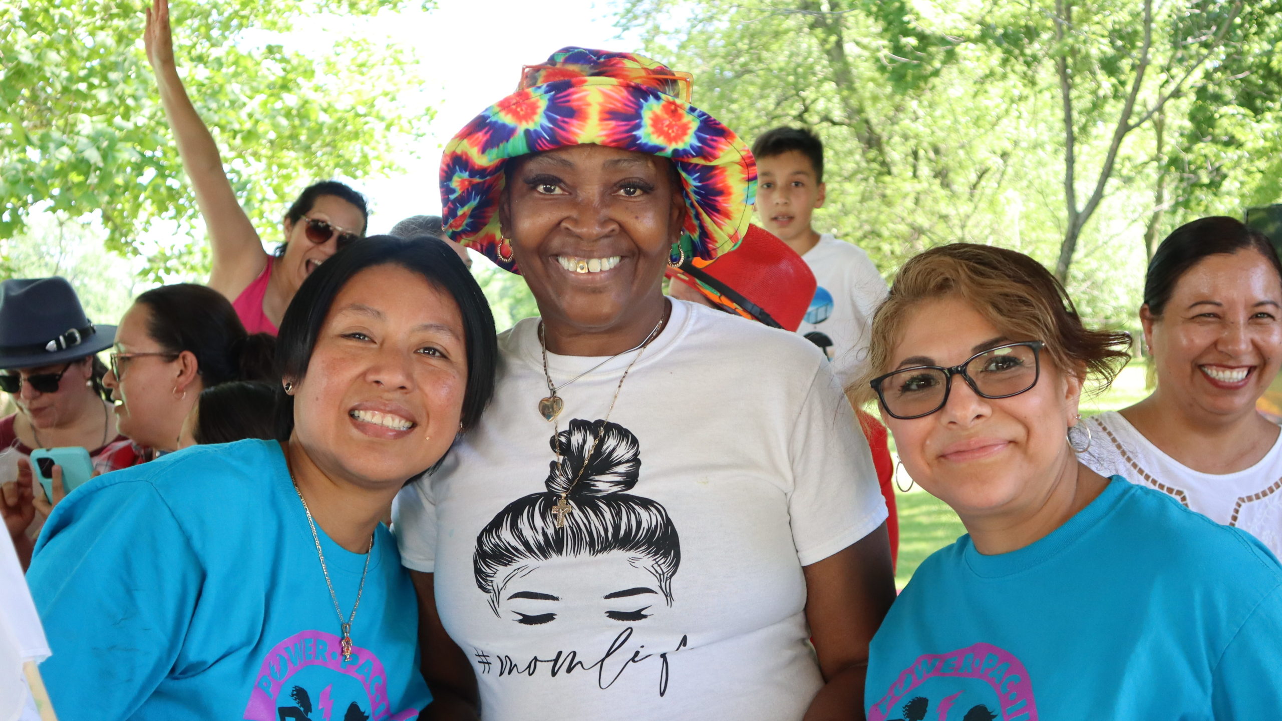 Three parent leaders, all women, pose for a photo at a COFI celebration picnic
