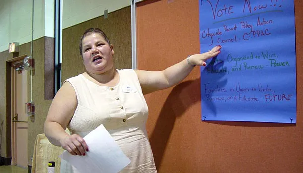 Una mujer señala un letrero que tiene tres nombres posibles para una futura coalición de padres