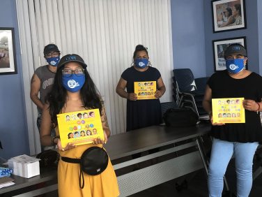 4 mujeres, con máscaras, sostienen coloridos volantes del Censo 2020 para divulgación