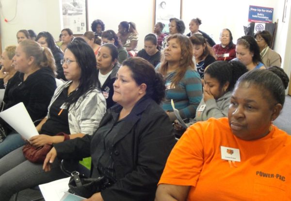 An audience of about 30 Black and Latinx women sitting 