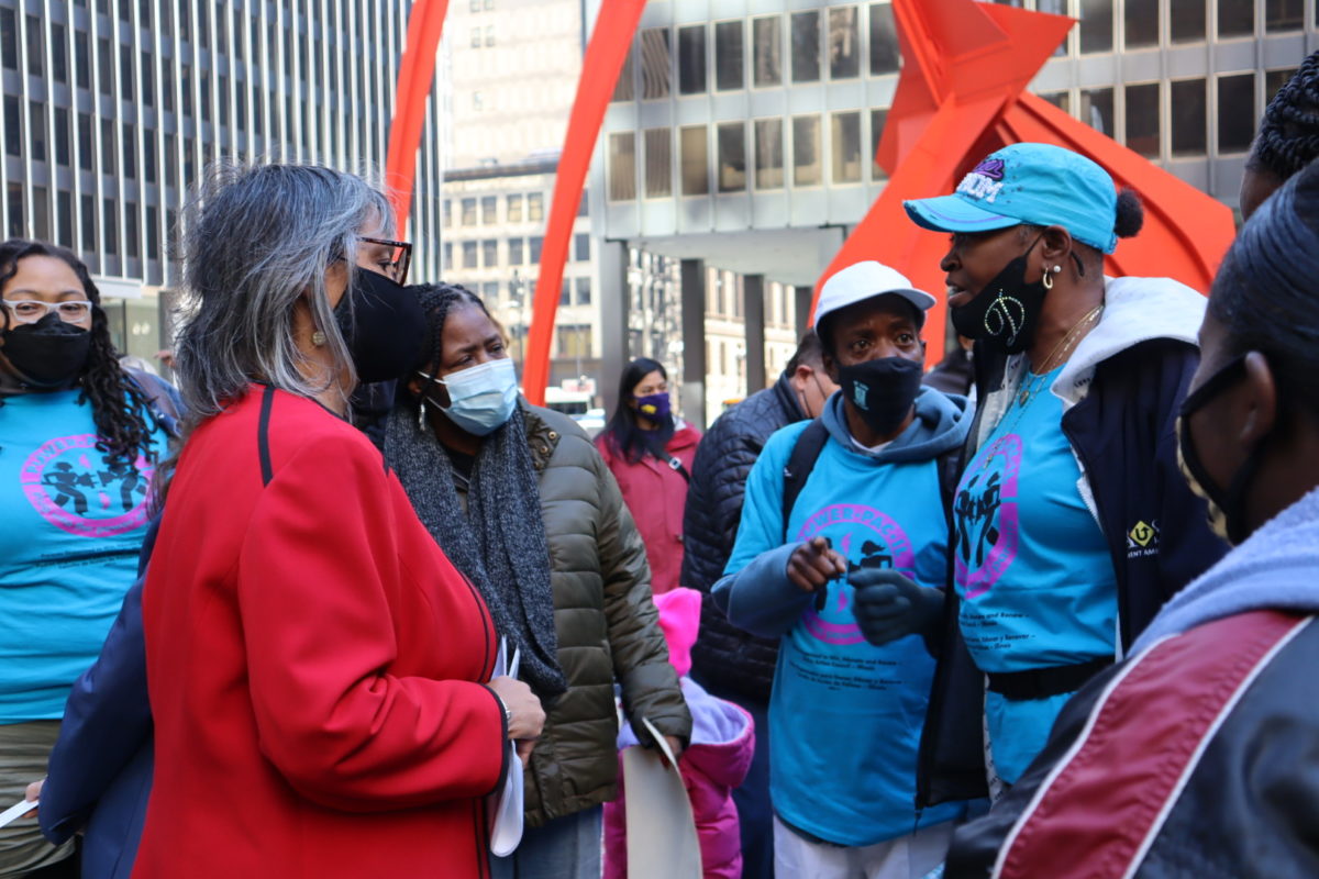 Los líderes de POWER-PAC IL hablan con un legislador del estado de Illinois en un mitin en Chicago