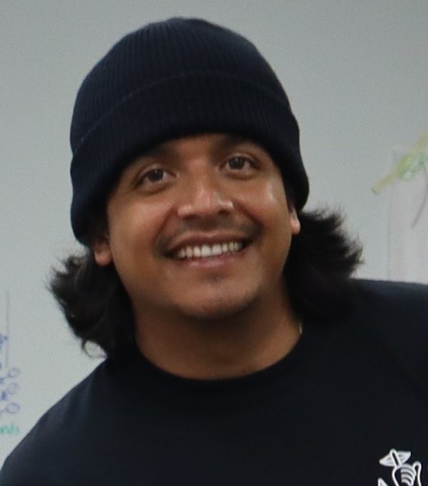 Hombre latino con gorra negra sonríe