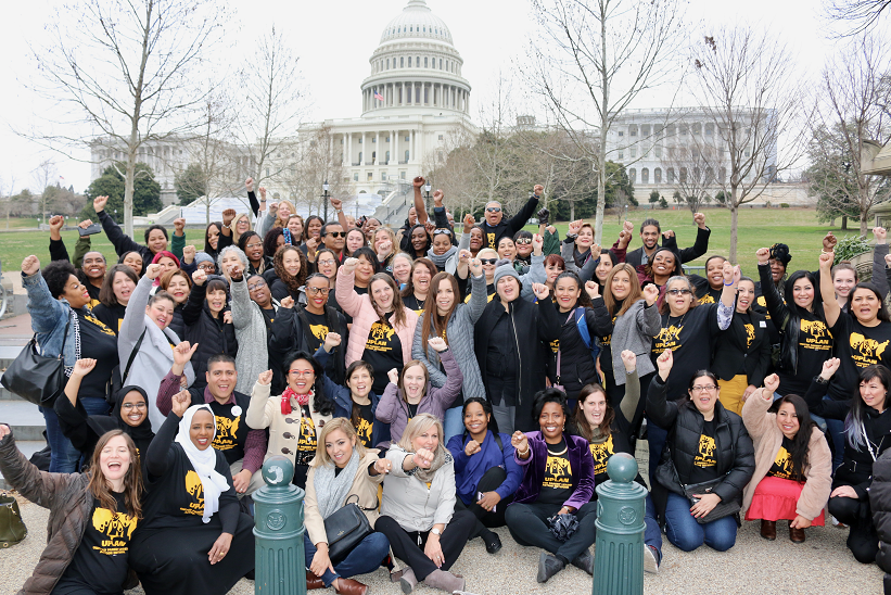 A large group of UPLAN parents pose for a photo in front of the US Capitol