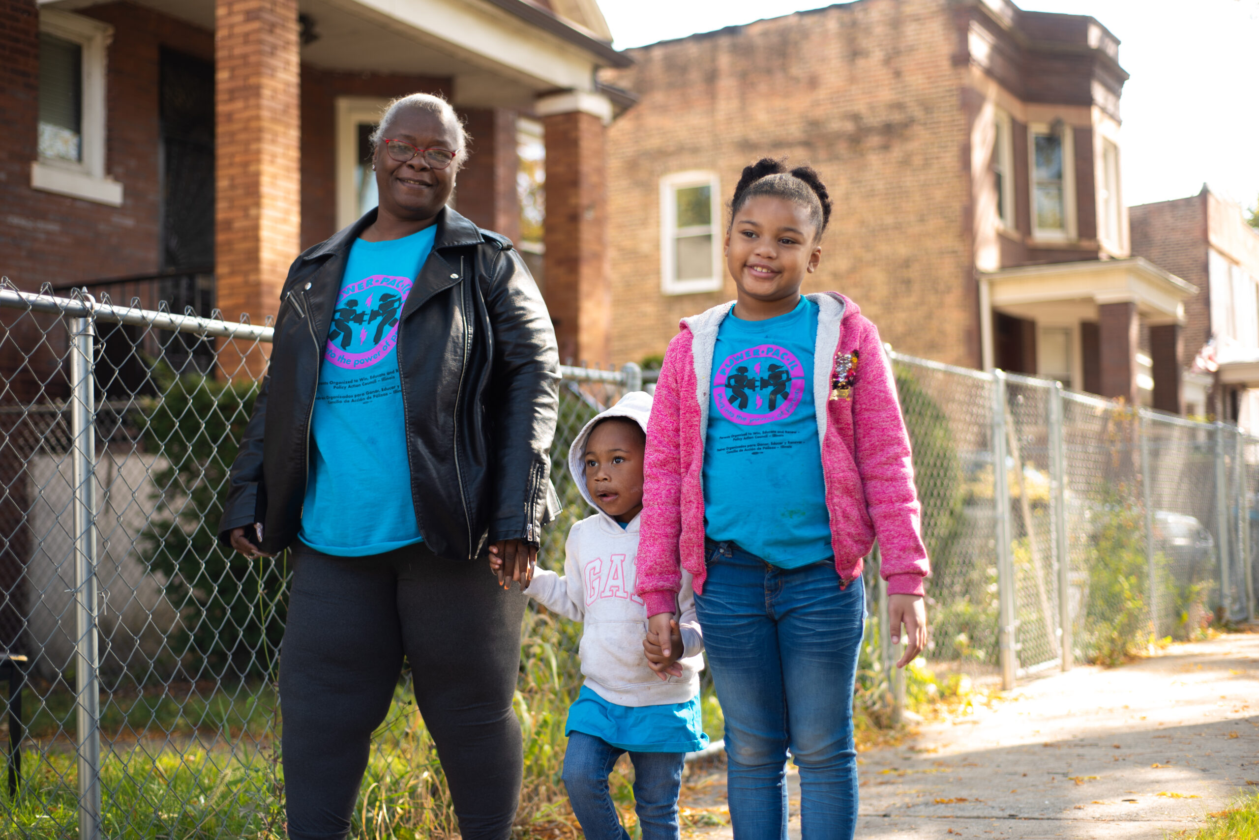 A grandma is walking and holding hands with two granddaughters