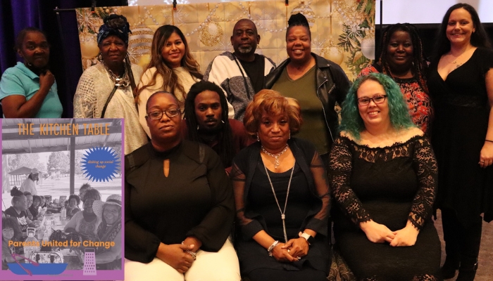 Members of the East St. Louis branch, Parents United for Change, pose for a photo. The cover of their cookbook can be seen in the corner of the image.