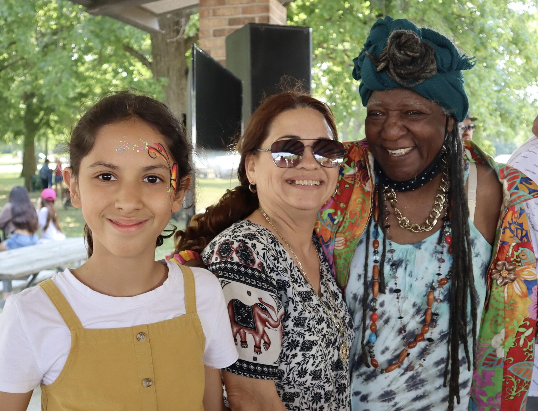 A Latina teenager, her mom, and an African-American grandmother pose for a photo at the Celebration of Hope picnic