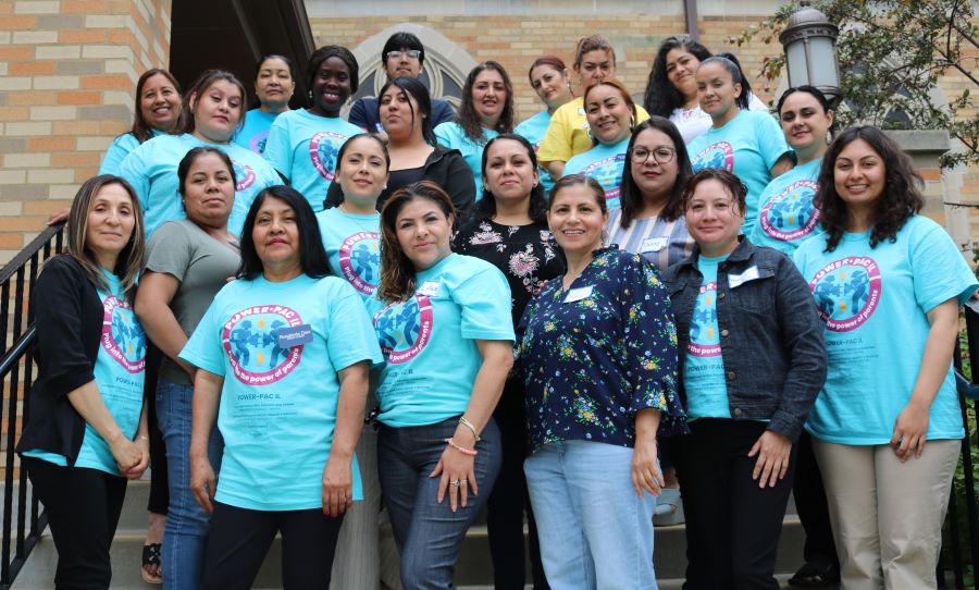 A group picture from the Aurora town hall. There are about 22 women and one man standing on a few rows of stairs