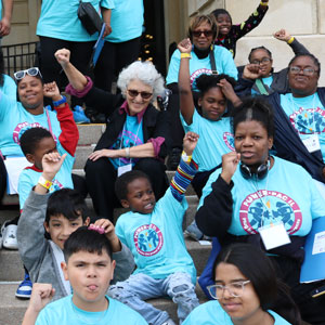 Ellen and POWER-PAC IL leaders and children in Springfield with their fists up in the ai