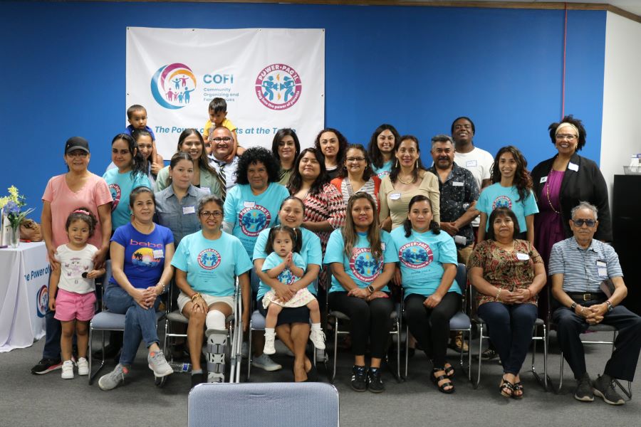 Una foto de grupo del foro comunitario Fase 2: Acción y alcance comunitario de Elgin. Hay alrededor de 28 personas en la imagen, incluidos unos cuatro niños pequeños.