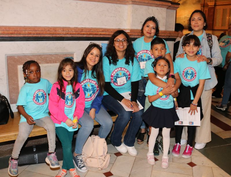 Four adults pose for a picture with five kids 