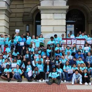 A large group of parents and children sitting on the steps of the Illinois Capitol Building