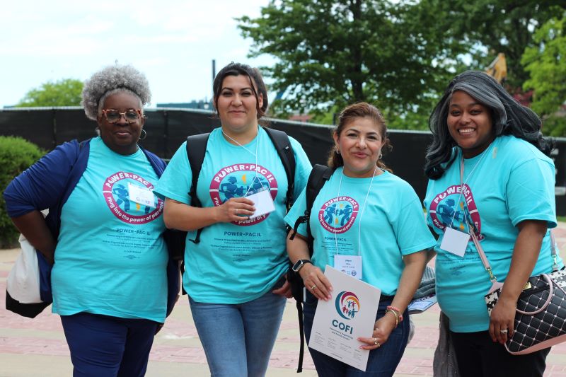 Cuatro mujeres se levantan y sonríen para una foto grupal