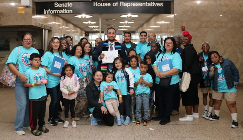 A large group photo of about 17 parent leaders and about 9 children with Javier Cervantes